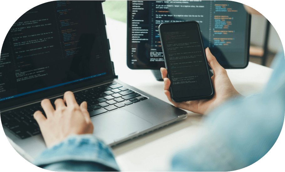 Person reviewing code on a phone and laptop